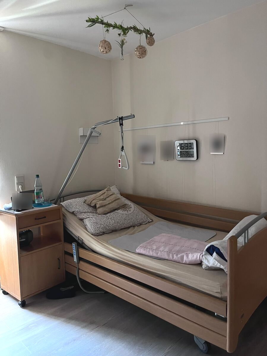 Bewohnerzimmer mit Pflegebett und persönlicher Einrichtung